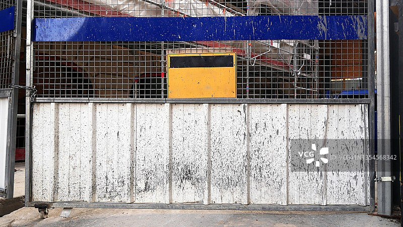 建筑工地网格上的空黄色和黑色金属标志图片素材