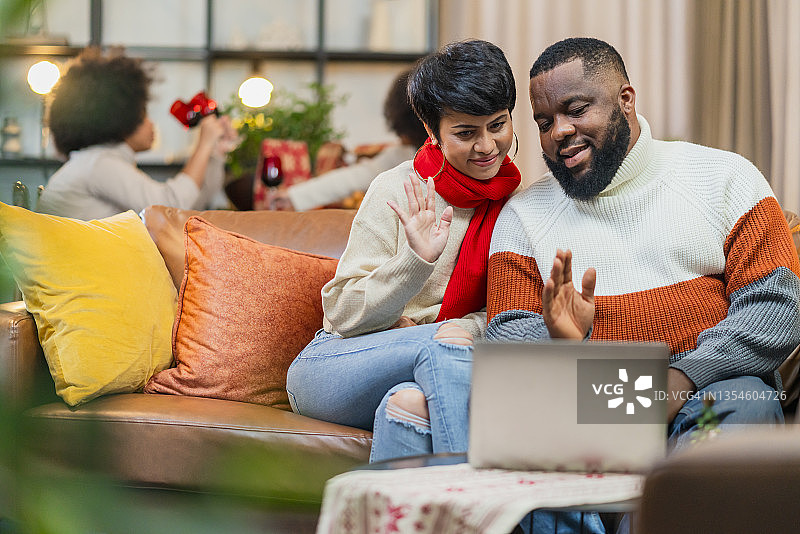 混血夫妇与亲戚视频通话，幸福的已婚夫妇在家中使用平板电脑进行视频通话，与亲人联系可以消除封锁带来的忧郁图片素材