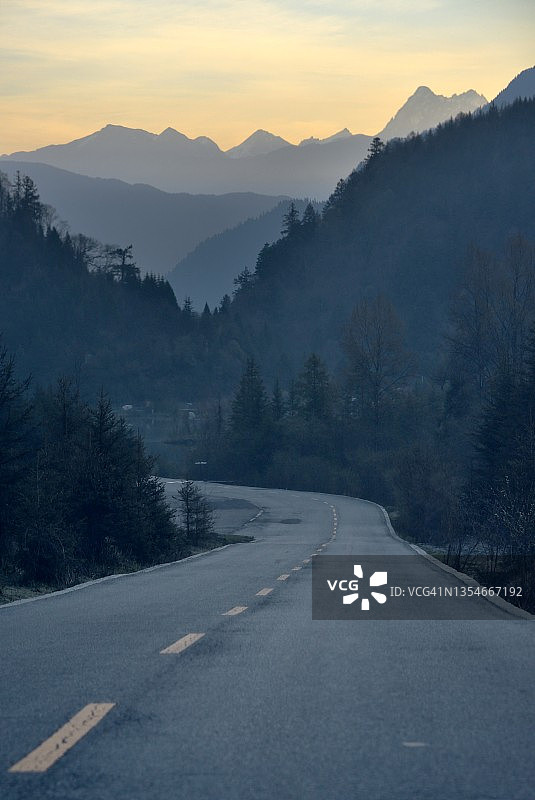 中国西部晨光中的山路图片素材