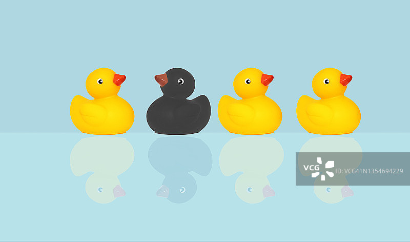 蓝色背景上的黑色橡胶鸭玩具图片素材