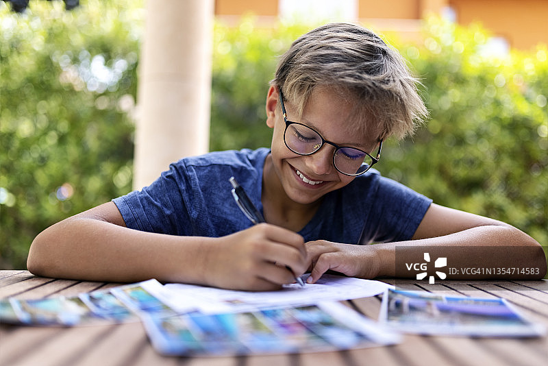 书写明信片的青少年男孩图片素材