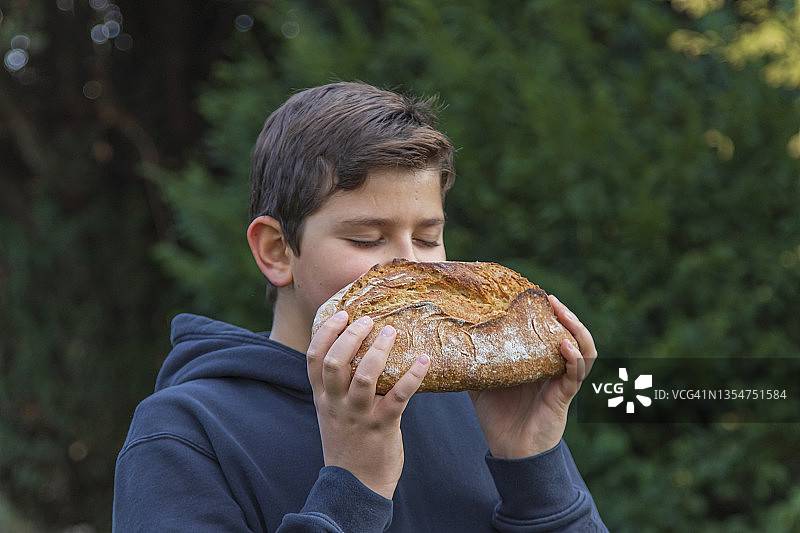 户外闻面包香味的儿童图片素材