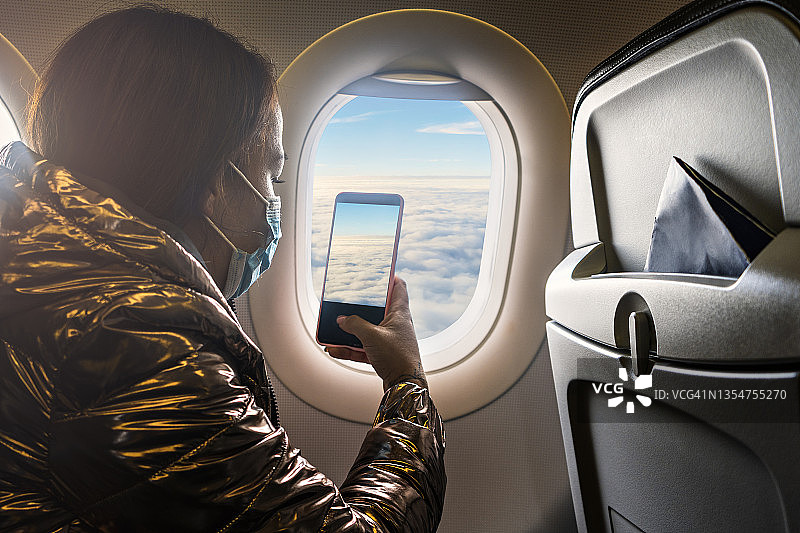 女人在飞机窗口拍照图片素材