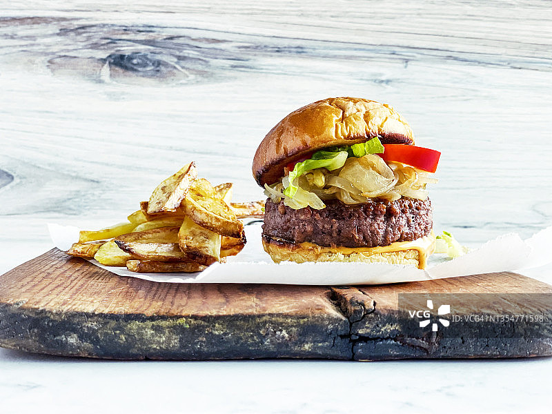 木制砧板上的汉堡和薯条图片素材