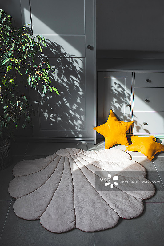 温馨的儿童游戏室，配有手工纺织垫和黄色枕头图片素材