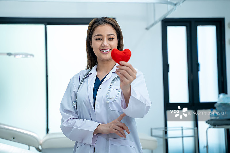 年轻女医生在医院办公室手捧红心图片素材