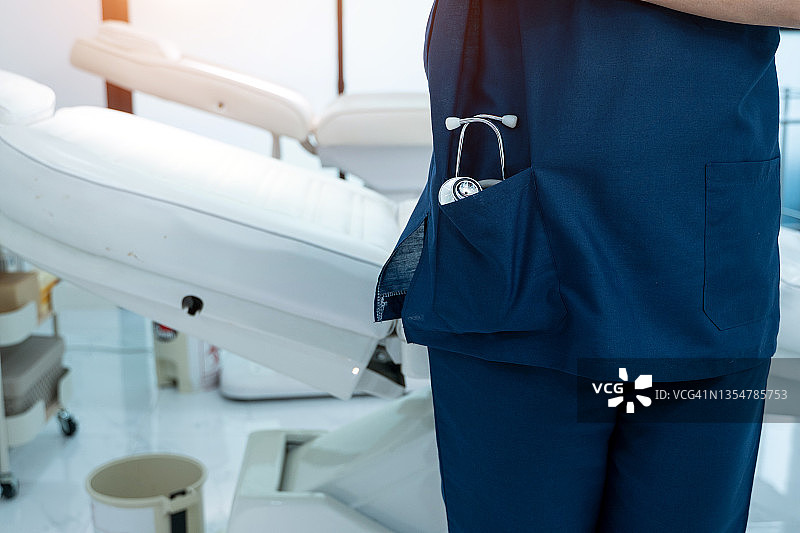 医院里穿蓝色制服手持听诊器医生特写图片素材