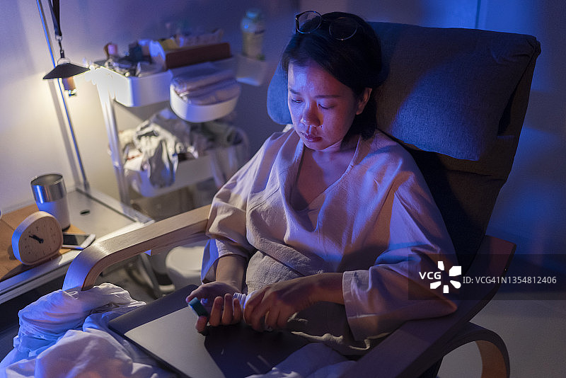 年轻女子深夜在卧室感到沮丧并服用药物帮助睡眠图片素材