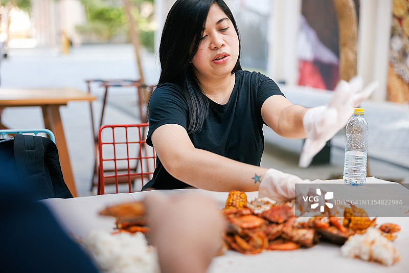 女人在餐厅餐桌上用手机吃海鲜图片素材