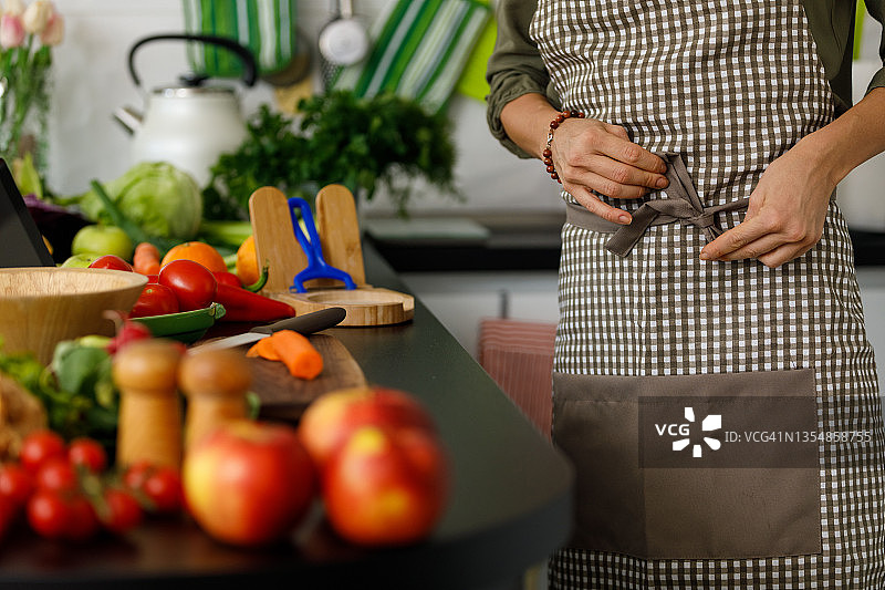 妇女系上围裙的腰部特写图片素材