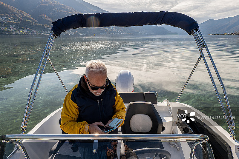 成熟男人秋季在湖上驾船图片素材