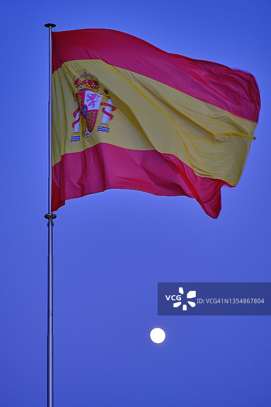 蓝色时刻和月亮下的西班牙国旗图片素材