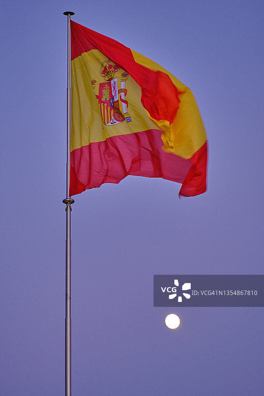 蓝色时刻和月亮下的西班牙国旗图片素材