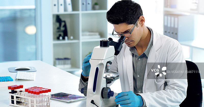 年轻男科学家在实验室使用显微镜图片素材