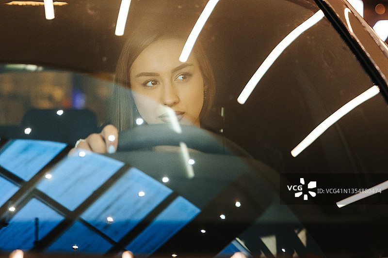 年轻女子在豪华车中享受未来感体验图片素材