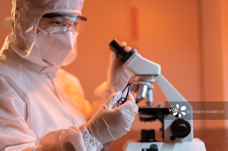 女工程师在无尘实验室检查晶圆芯片图片素材