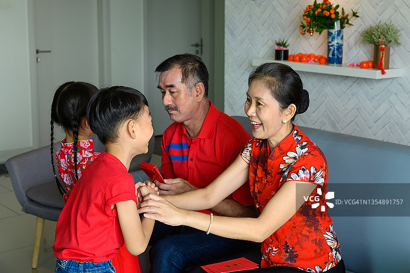 中国新年期间，孙子和孙女收到祖父母的红包图片素材