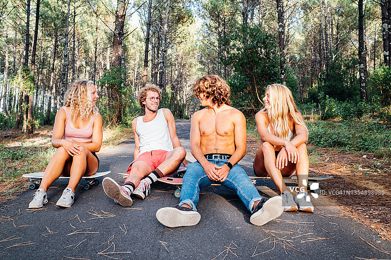 坐在森林木板上的滑板运动员图片素材