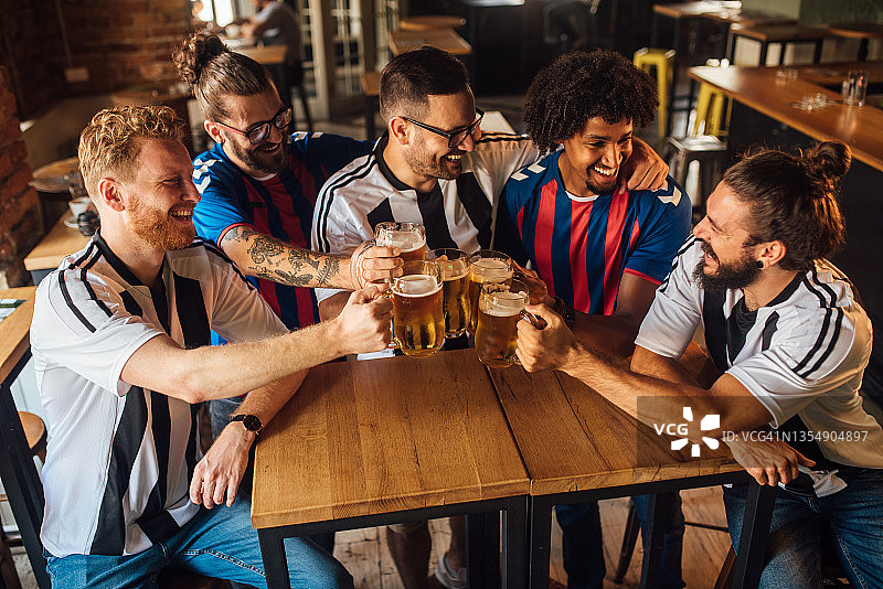 聚集在酒吧喝酒庆祝胜利的足球迷图片素材