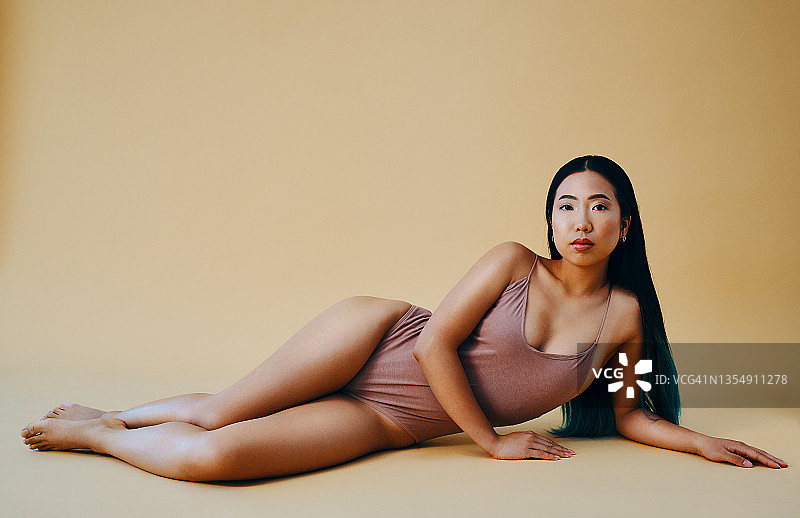 年轻女子在工作室摆姿势全身照图片素材