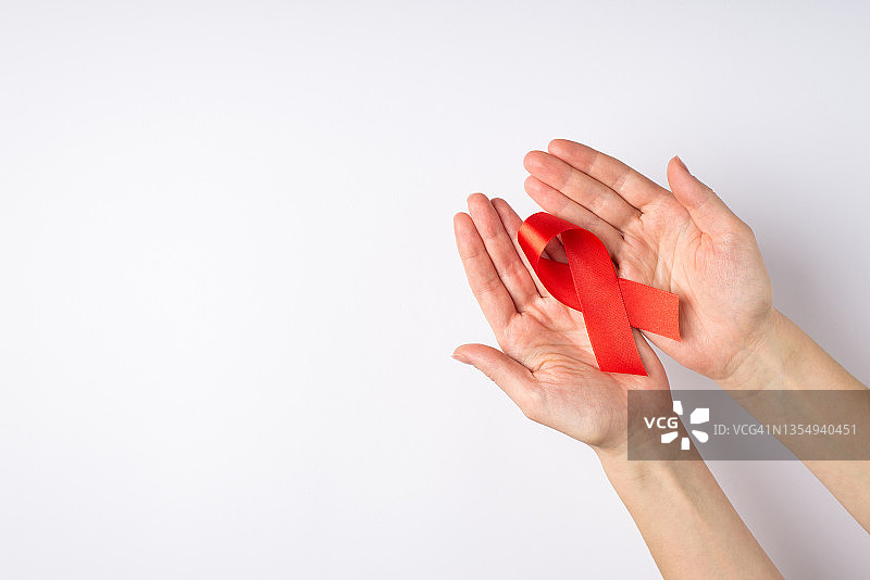 手持红色缎带，关注艾滋病图片素材