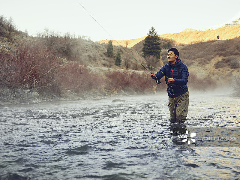 在犹他州普罗沃河飞蝇钓鱼的亚洲男人图片素材