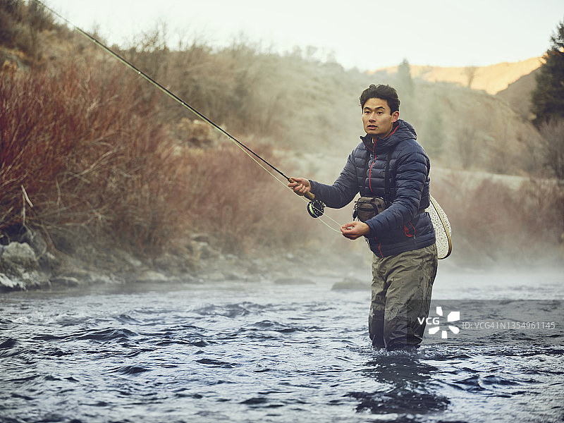 在犹他州普罗沃河飞蝇钓鱼的亚洲男人图片素材