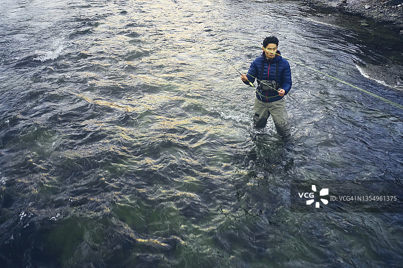 在犹他州普罗沃河飞蝇钓鱼的亚洲男人图片素材