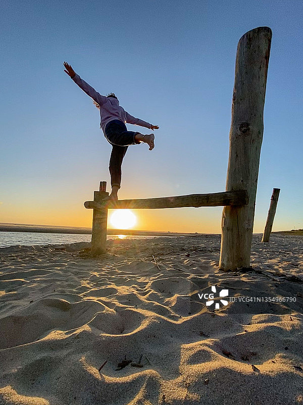 在海滩上平衡木上的女人。关于平衡生活的概念照片图片素材