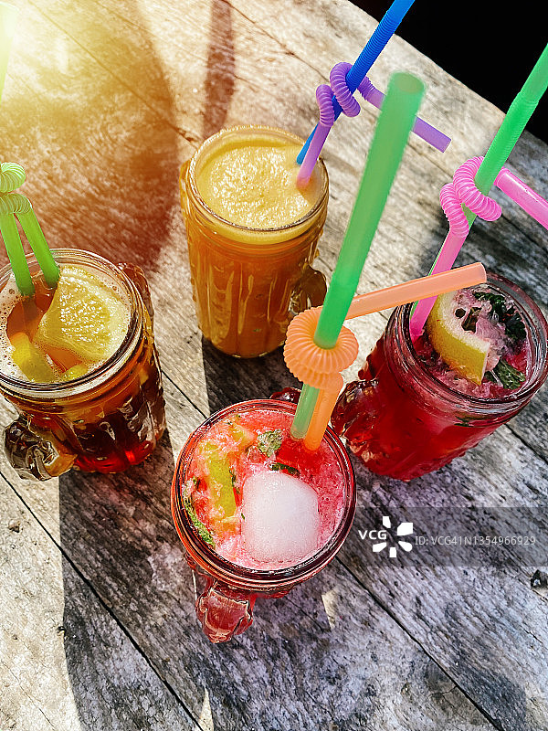 户外木桌上的草莓莫吉托酒杯的竖版照片图片素材