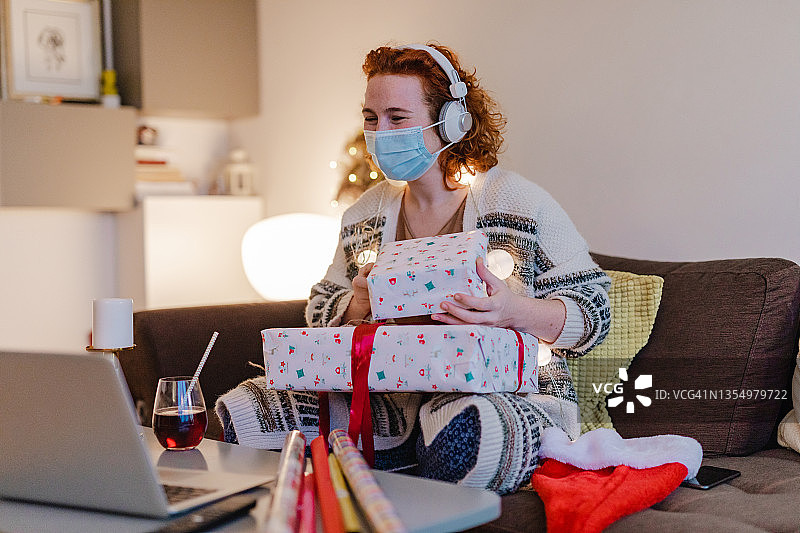 圣诞节期间戴口罩的女人正在进行视频通话图片素材