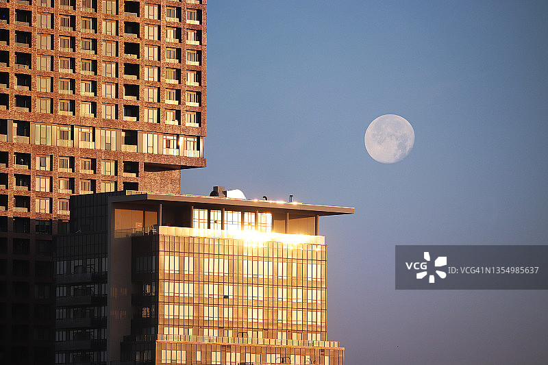 城市日出与满月倒影图片素材