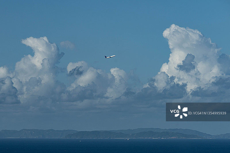 飞机在日本那霸市海滩上空飞行图片素材