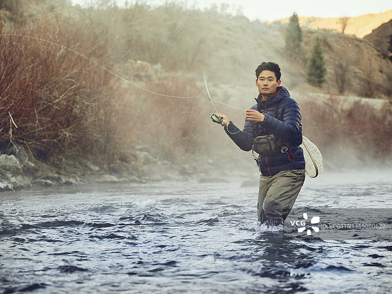 在犹他州普罗沃河飞蝇钓鱼的亚洲男人图片素材