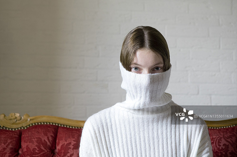 脸被白色高领毛衣遮住的少女图片素材