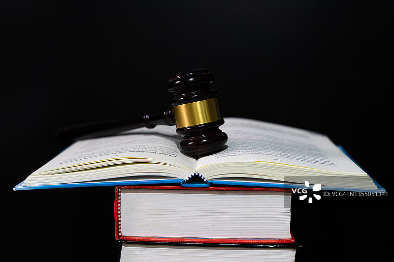法律与公正概念，黑色木质背景上的法官 gavel 和法律书籍，法律图书馆概念图片素材
