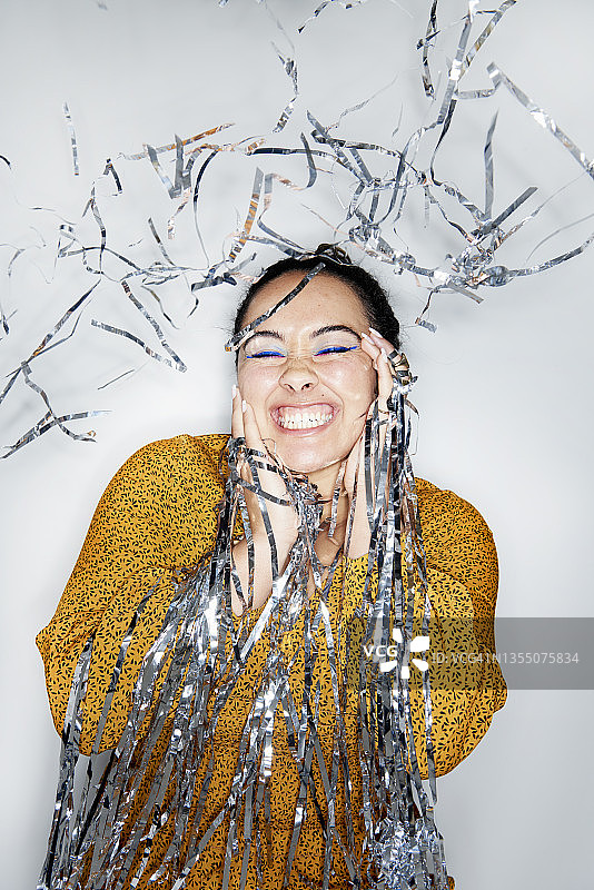 用银色派对彩带庆祝的女人肖像图片素材