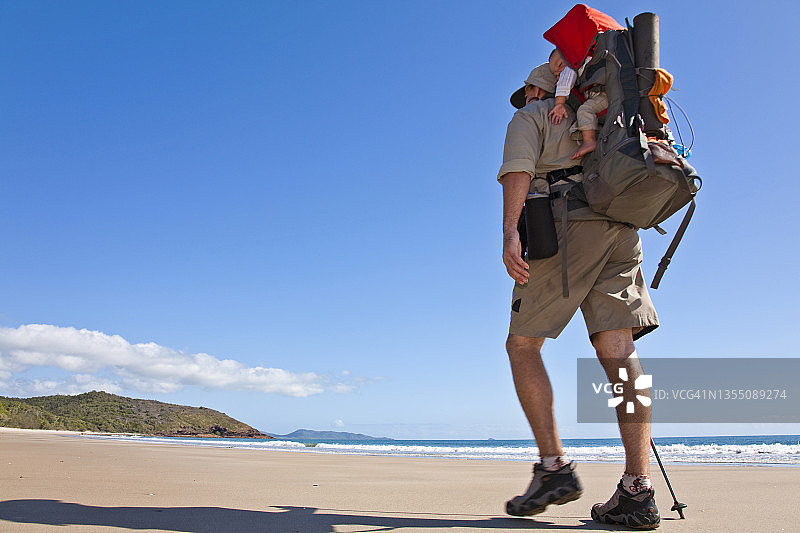 一名男子在澳大利亚昆士兰州欣钦布鲁克岛的佐伊湾徒步旅行，同时抱着他的孩子图片素材
