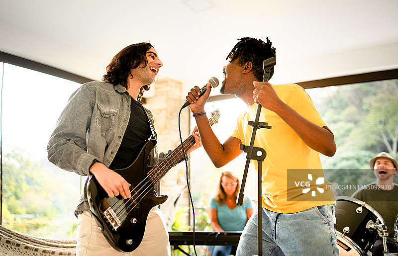 歌手兼贝斯手与乐队在家中工作室排练图片素材