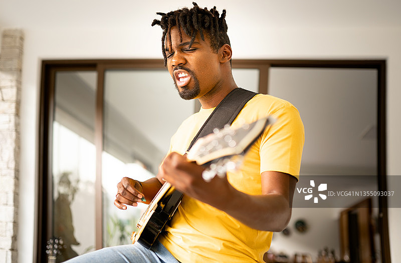 年轻男人在乐队排练时弹奏电吉他图片素材