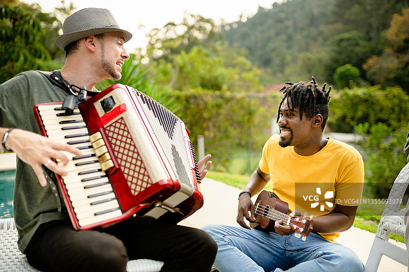 两位年轻音乐家在户外用不同的乐器即兴演奏图片素材
