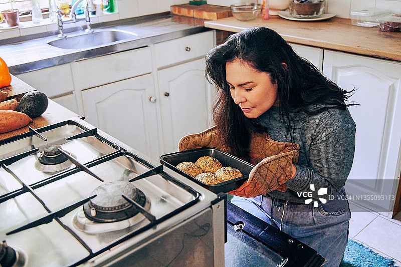 年轻女人闻刚出炉的面包卷香味照片图片素材
