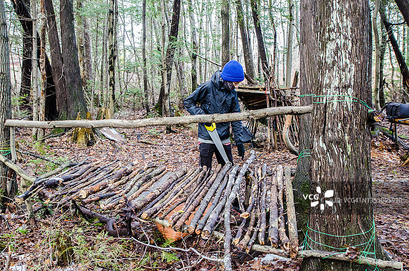 男孩在树林里搭建避难所图片素材