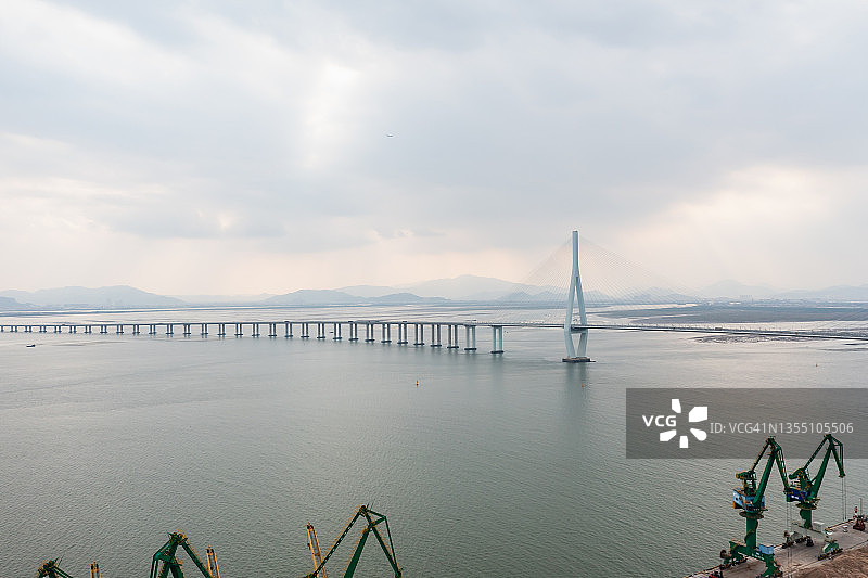 阴天里的港口和远处的桥梁图片素材