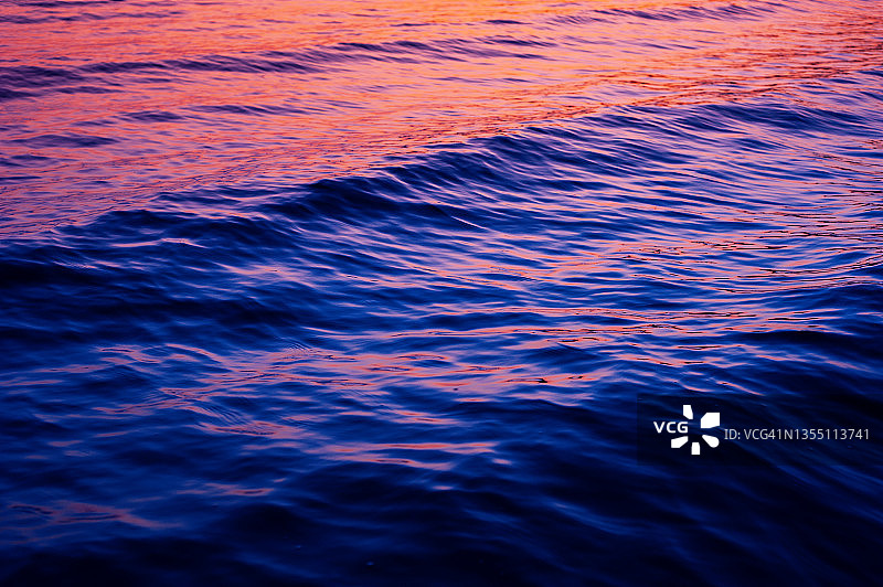 紫色日落倒影下的水面纹理图片素材