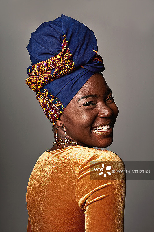 年轻女人戴着非洲传统头巾，以灰色为背景的照片图片素材