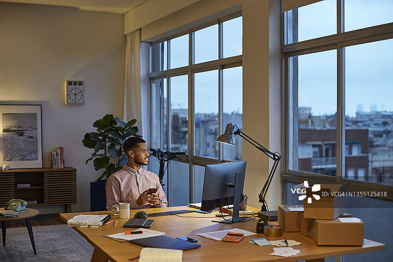 沉思的商人在家办公，看向远方图片素材