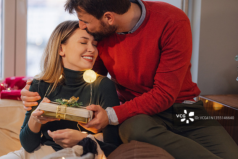 男人在家中送给女人一份圣诞礼物图片素材