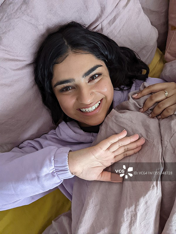 在沙发上坦率微笑的年轻女人图片素材