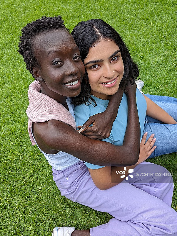 在户外拥抱微笑的年轻女性图片素材